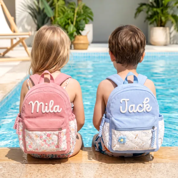 Toddlers wearing custom embroidered backpacks with names Mila and Jack